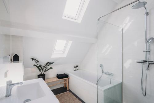 a bathroom with a tub and a sink and a shower at Big loft 100m from beach in Scheveningen