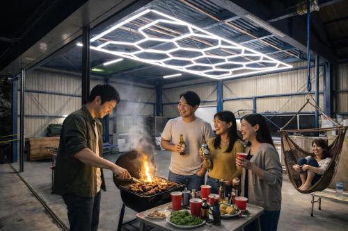 a group of people standing around a barbecue grill at 岐阜羽島の隠れ家 古民家cocone in Hashima