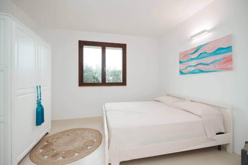 a white bedroom with a bed and a window at White House – Villa con Jacuzzi e Posto Auto in Otranto