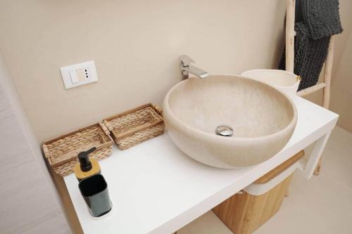 a bathroom with a sink and a bottle on a counter at White House – Villa con Jacuzzi e Posto Auto in Otranto