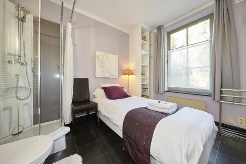 a bedroom with a bed and a shower and a sink at B&B Zinnen en Minnen in Herselt