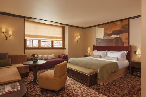 a hotel room with a large bed and a couch at Hotel Saint Roch in Courchevel