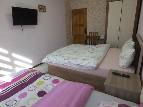 a small bedroom with two beds and a television at Samia House Room on Furqat 8 in Tashkent
