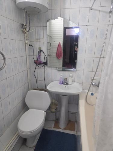 a white bathroom with a toilet and a sink at Samia House Room on Furqat 8 in Tashkent