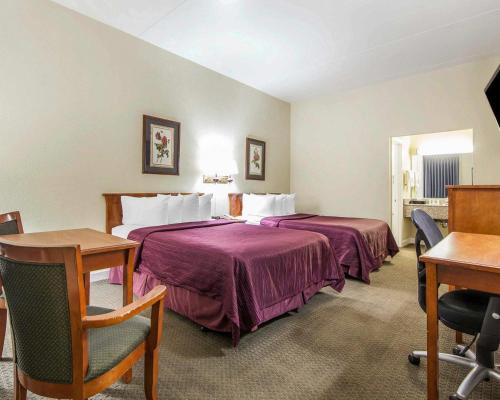 a hotel room with two beds and a desk at Quality Inn Maysville in Maysville