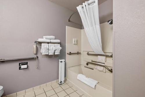 a bathroom with a shower and a toilet with towels at Quality Inn near Monument Health Rapid City Hospital in Rapid City