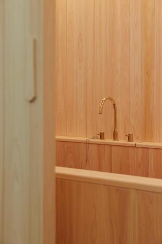a bathroom with a faucet on a wooden wall at Incheon No25 Hotel Seogu in Incheon