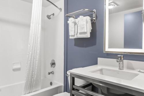 a white bathroom with a sink and a shower at Quality Inn & Suites Nashville - Bellevue in Nashville