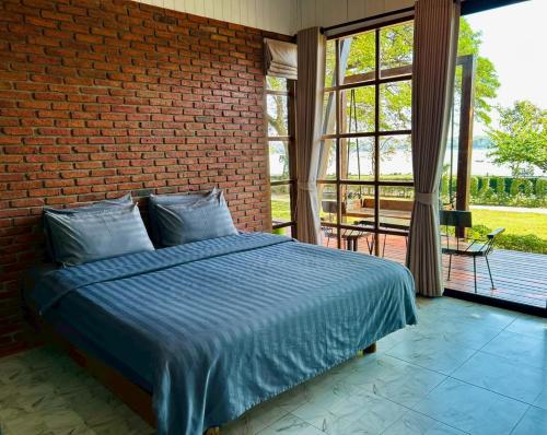 a bedroom with a bed and a brick wall at บ้านเคียงสะหวัน in Muang Phaluka
