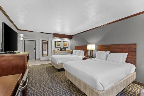 a hotel room with two beds and a flat screen tv at Radisson Hotel Salt Lake City Airport in Salt Lake City
