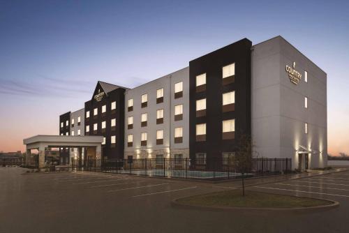 a building with a parking lot in front of it at Country Inn & Suites by Radisson, Oklahoma City - Bricktown, OK in Oklahoma City