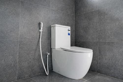 a white toilet in a bathroom with a hose at Jackhill Hiriketiya in Dickwella