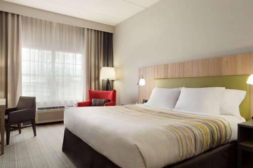 a hotel room with a bed and a desk and chair at Country Inn & Suites by Radisson, Jackson, TN in Jackson