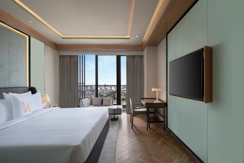 a hotel room with a bed and a tv at WelcomHotel by ITC Hotel Mohali, Chandigarh in Chandīgarh