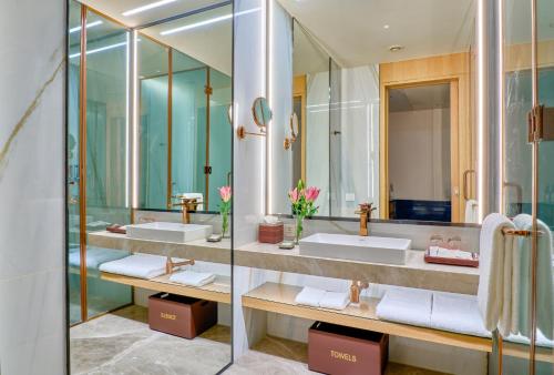 a bathroom with two sinks and a large mirror at WelcomHotel by ITC Hotel Mohali, Chandigarh in Chandīgarh