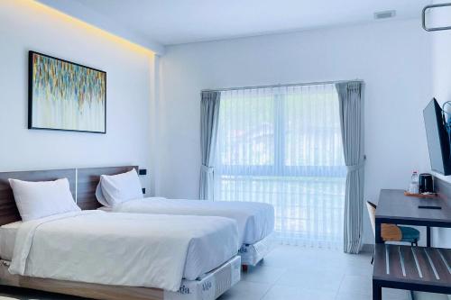 a hotel room with two beds and a window at Alfa Jivana Resort in Sampal 2