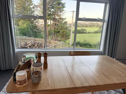 a wooden table in front of a large window at Sunny Spacious Room, Free Parking, Close to Ferry in Wellington