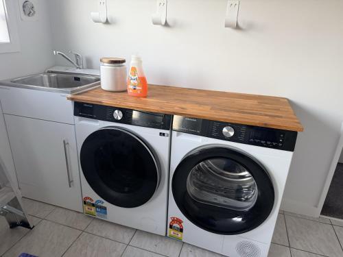 a washer and dryer in a kitchen with a sink at Sunny Spacious Room, Free Parking, Close to Ferry in Wellington