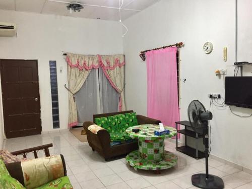 a living room with a couch and a table at IMADUDDEEN Homestay in Kampong Bukit Kuang