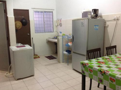 a kitchen with two refrigerators and a table and a sink at IMADUDDEEN Homestay in Kampong Bukit Kuang