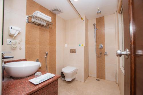 a bathroom with a sink and a shower and a toilet at Bodhi Suite Boutique Hotel & Wellness in Pokhara