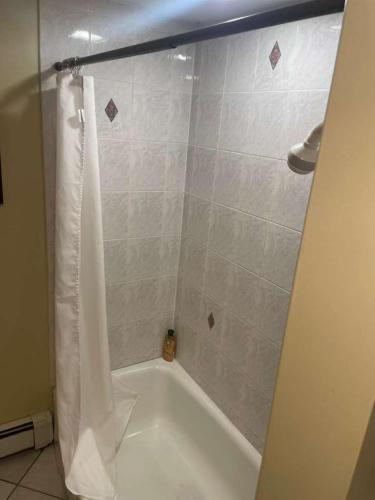 a white bath tub with a shower curtain in a bathroom at Homestay in Boston Pearl Street in Boston