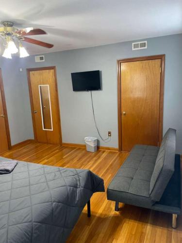 a bedroom with a bed and a chair and a flat screen tv at Homestay in Boston Pearl Street in Boston