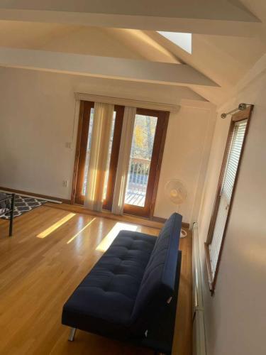 a living room with a blue couch in front of a window at Homestay in Boston Pearl Street in Boston