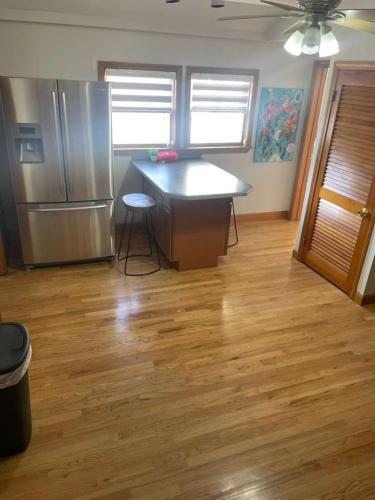a kitchen with a counter and a refrigerator and wooden floors at Homestay in Boston Pearl Street in Boston
