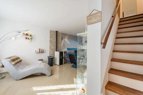 a living room with a staircase and a chair at La douce echappée in Trèbes