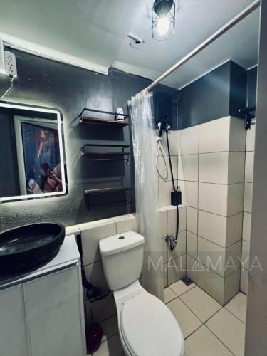 a bathroom with a toilet and a sink at Malamaya Staycation in Manila