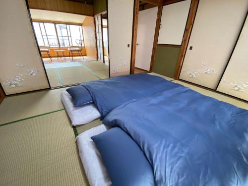ein großes blaues Bett in einem Zimmer mit Spiegeln in der Unterkunft あかり庵 in Iki