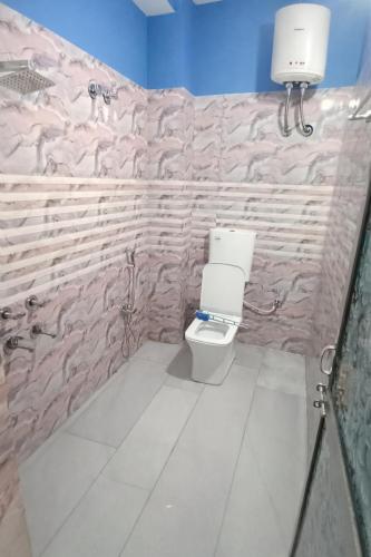 a bathroom with a toilet and a stone wall at Hotel DEEPAK PALACE in Gaya