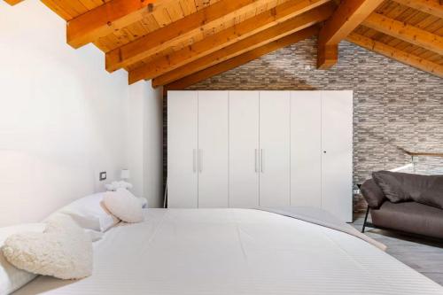 a teddy bear sitting on a bed in a bedroom at Luxury Lakeview Loft in Baveno