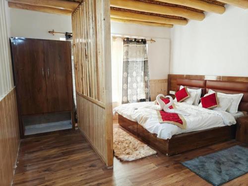 a bedroom with a bed with white sheets and red pillows at The Snowpeak Hunder in Hundar
