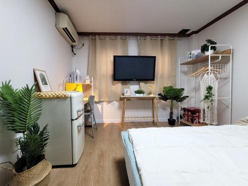 a bedroom with a bed and a tv on a wall at the stay Paju in Paju