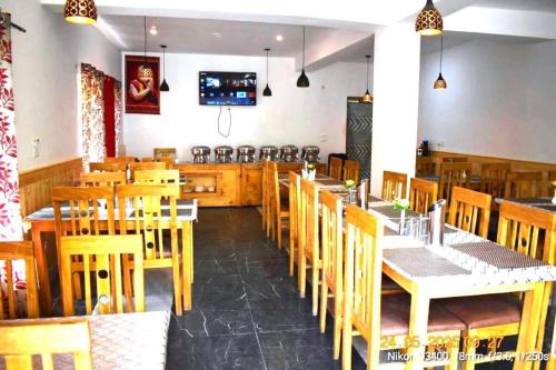 a dining room with wooden tables and chairs at The Snowpeak Hunder in Hundar