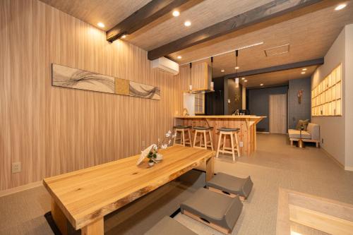 a dining room with a wooden table and chairs at JAPAVISTA Yumeno in Osaka
