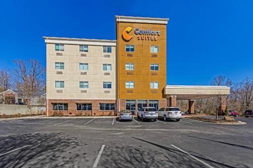 a building with a car dealership in a parking lot at Comfort Suites Huntsville MidCity District at Research Park in Huntsville