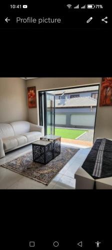 a picture of a living room with a couch and a table at Ee40Yethu in Pretoria