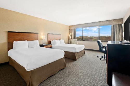 a hotel room with two beds and a desk at Quality Hotel Philadelphia Airport in Essington