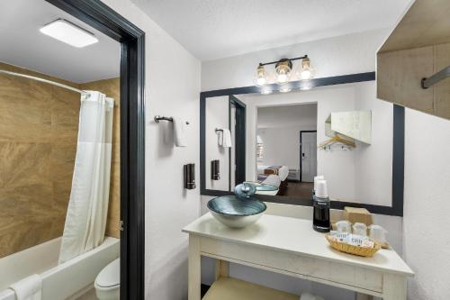 a bathroom with a sink and a mirror at Rodeway Inn Llano in Llano