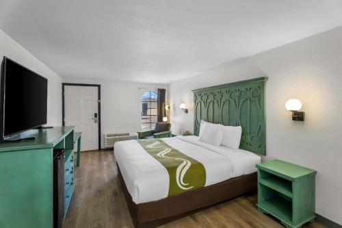 a hotel room with a large bed and a flat screen tv at Rodeway Inn Llano in Llano