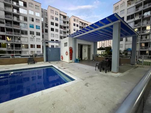 a building with a swimming pool and a blue canopy at El encanto de Cartagena in Cartagena de Indias