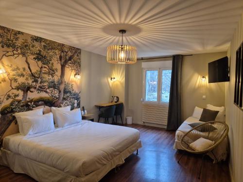 a bedroom with a large bed and a chandelier at Logis Hôtel Restaurant Les Norias in Cazilhac