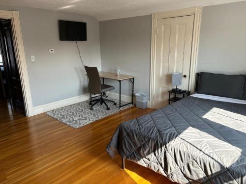 a bedroom with a bed and a desk with a chair at HomeStay in Harvest Street in Boston