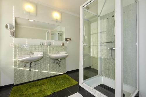 a bathroom with two sinks and a shower at B&B Zinnen en Minnen in Herselt