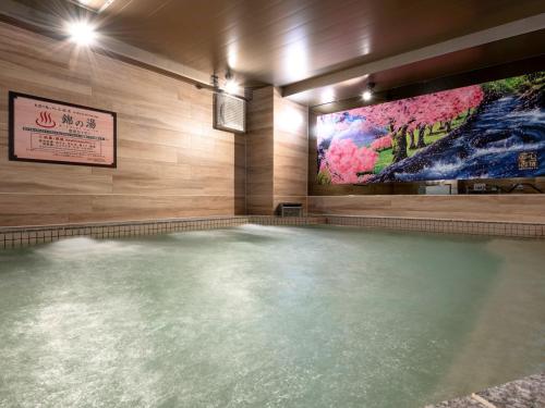 a pool of water in a room with a painting on the wall at 2025 RENEWAL OPEN Anshin oyado Nagoya Man & Woman Sakae Station in Nagoya