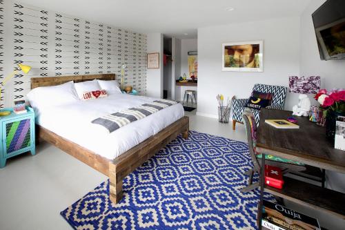 a bedroom with a bed and a blue and white rug at Hotel Dylan in Woodstock