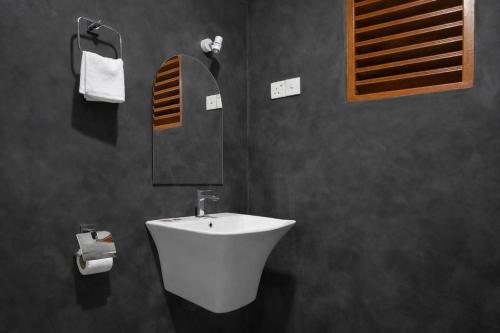 a bathroom with a white sink and a mirror at Muthu Hiriketiya in Dickwella